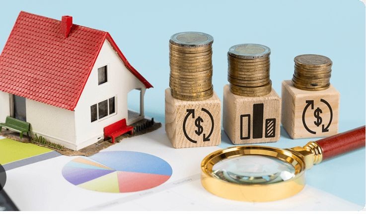 ### Image ALT Text  "Miniature house next to stacks of coins on wooden blocks with financial symbols, a magnifying glass, and a pie chart, representing real estate investment and property management services.